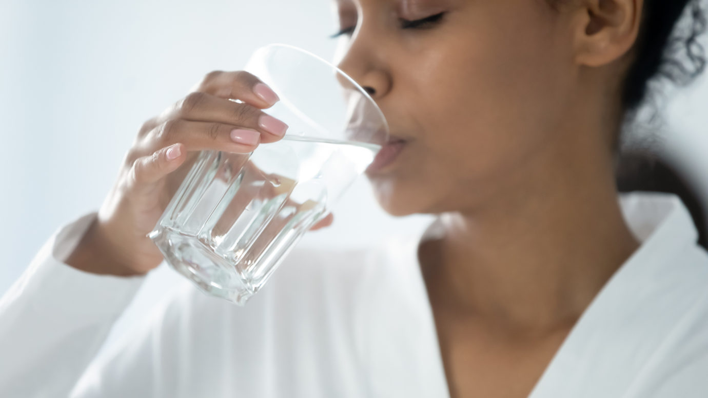Closeup image woman holding glass drinking still water