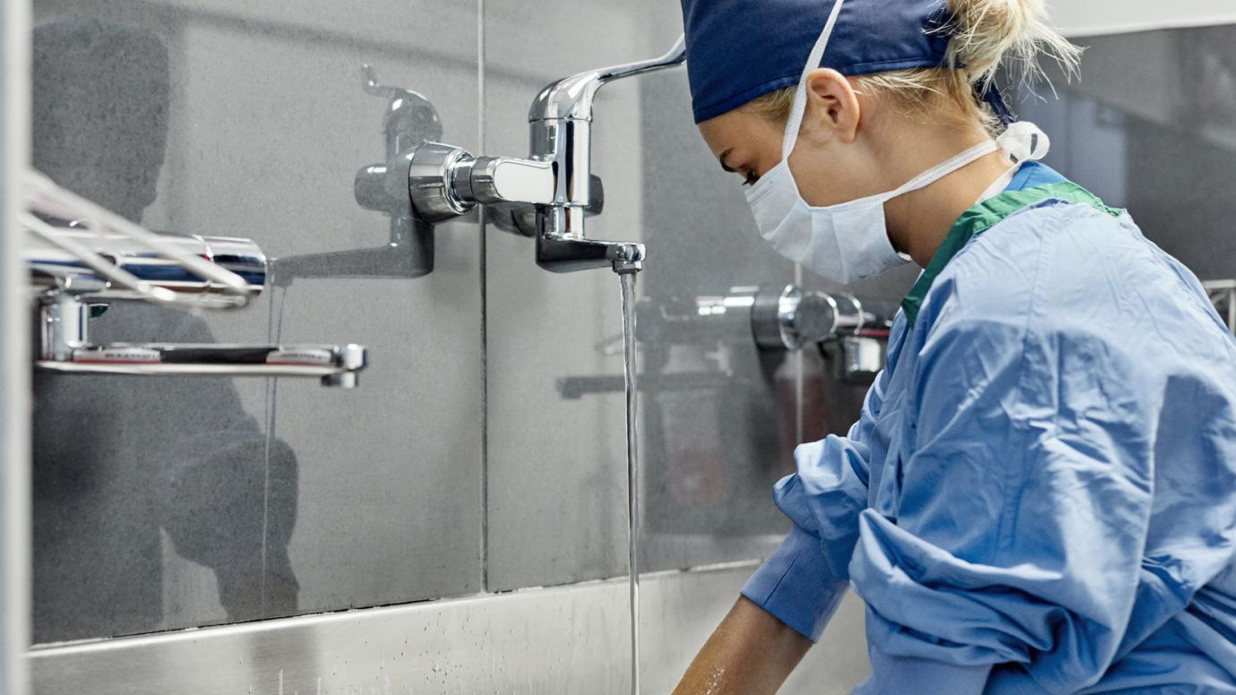 female surgeon washing hands